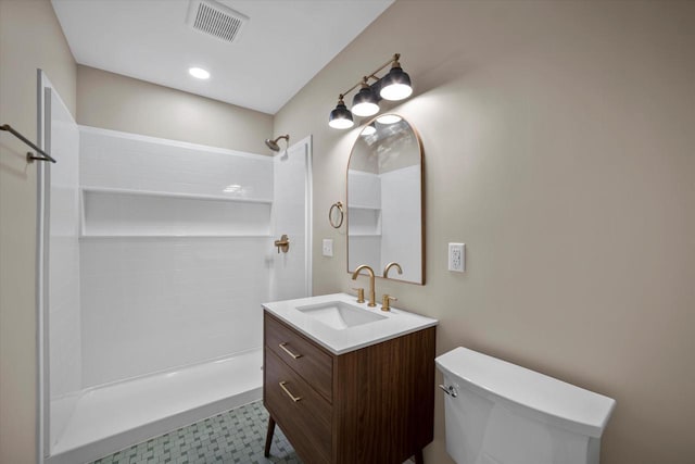 bathroom featuring vanity, toilet, and walk in shower