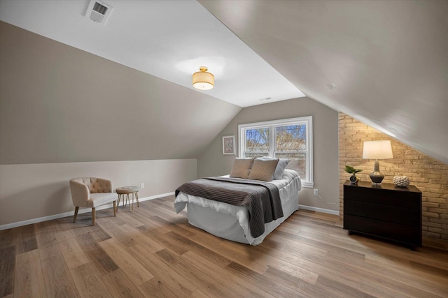 bedroom with vaulted ceiling and light hardwood / wood-style flooring