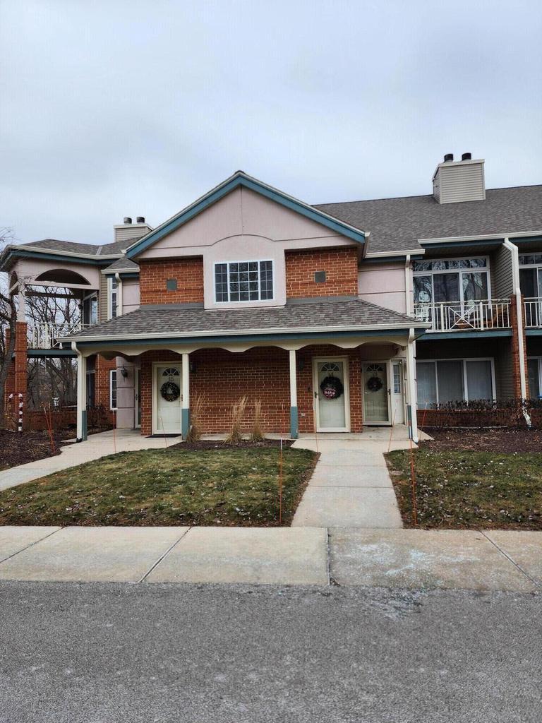 multi unit property featuring covered porch and a front yard