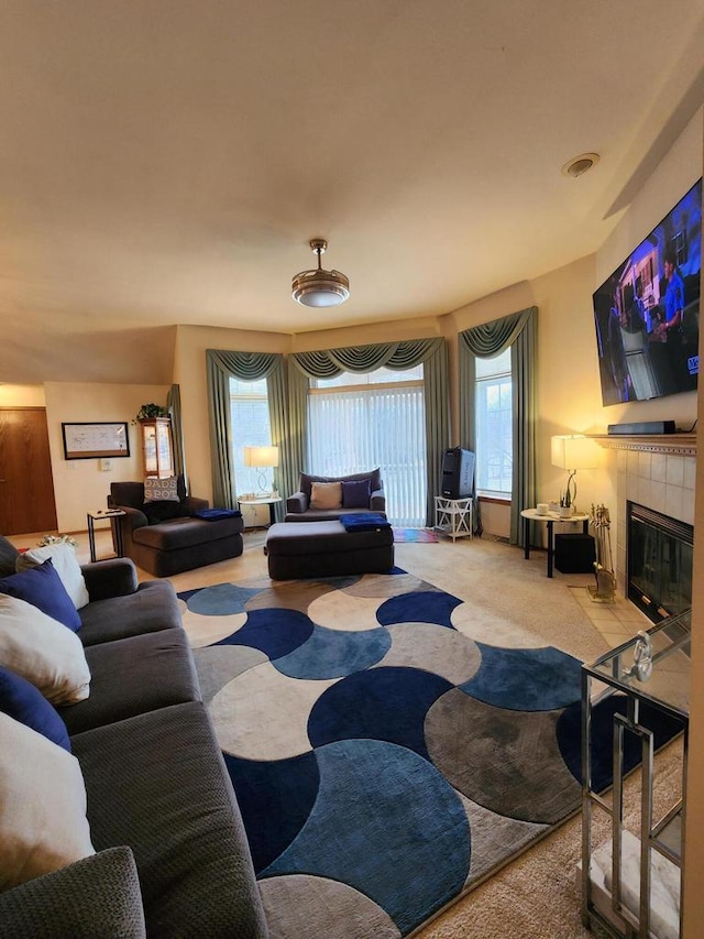 carpeted living room featuring a tiled fireplace