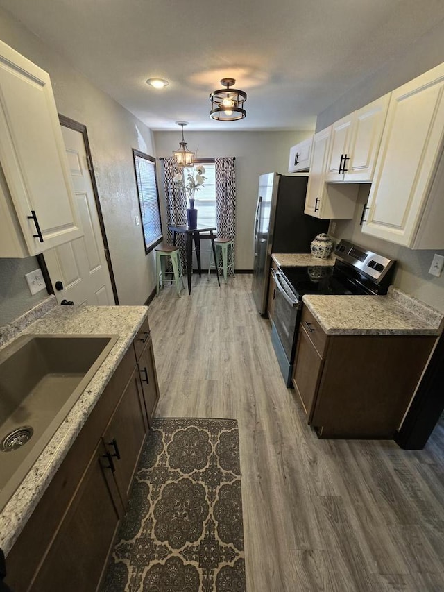 kitchen featuring dark brown cabinetry, an inviting chandelier, white cabinetry, and stainless steel range with electric stovetop