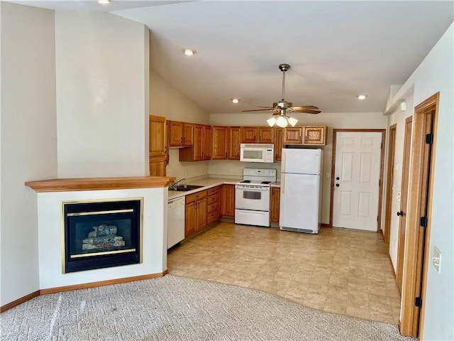 kitchen with light carpet, white appliances, ceiling fan, sink, and lofted ceiling