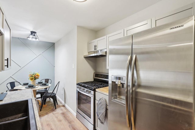 kitchen featuring white cabinetry, light wood-type flooring, and appliances with stainless steel finishes