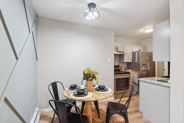 dining room with a baseboard radiator and light hardwood / wood-style flooring