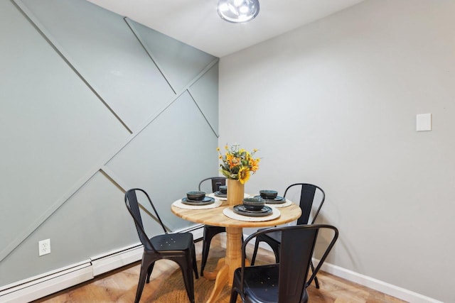 dining space featuring hardwood / wood-style flooring and a baseboard heating unit