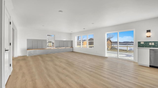 unfurnished living room with light hardwood / wood-style floors and a water view