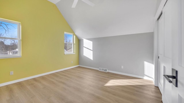 bonus room featuring a healthy amount of sunlight, light hardwood / wood-style floors, and lofted ceiling