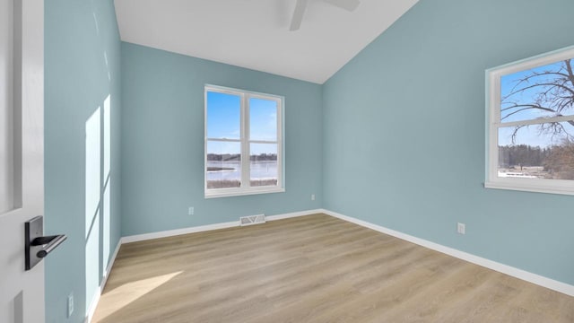 unfurnished room featuring ceiling fan, plenty of natural light, vaulted ceiling, and light hardwood / wood-style flooring