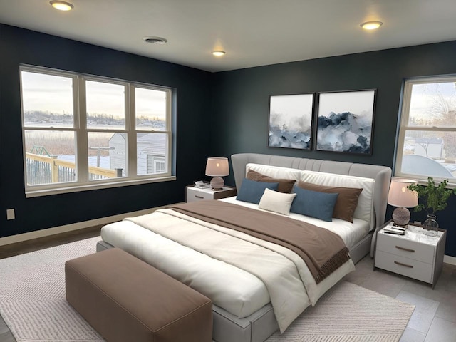 bedroom featuring a water view and light hardwood / wood-style flooring