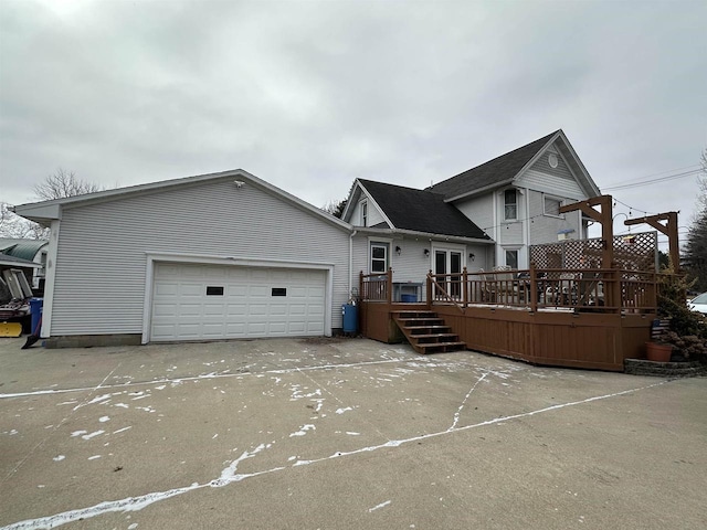 back of house with a garage and a deck