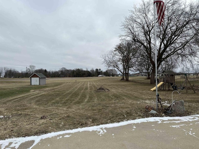 view of yard featuring a playground and a storage shed