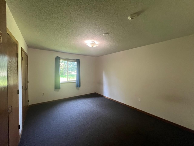 unfurnished room with a textured ceiling