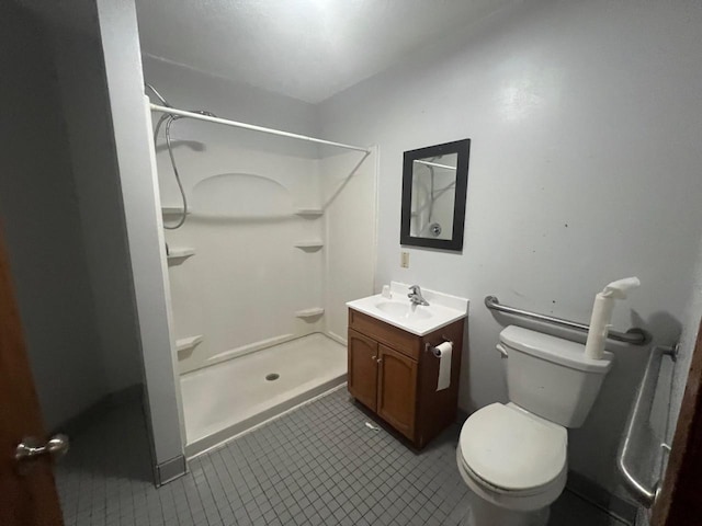 bathroom with a shower, vanity, toilet, and tile patterned flooring