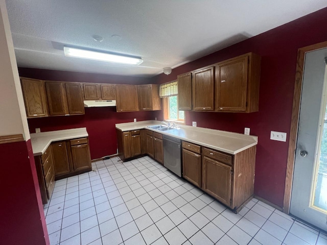 kitchen with dishwasher, light tile patterned floors, a textured ceiling, and sink