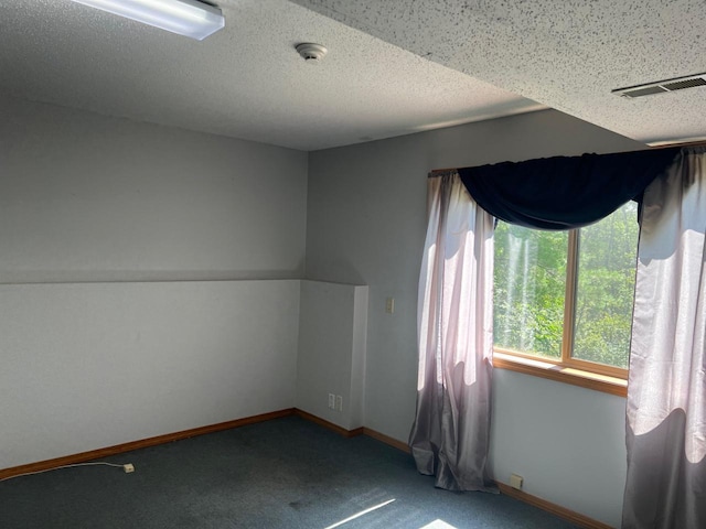 carpeted empty room with a textured ceiling