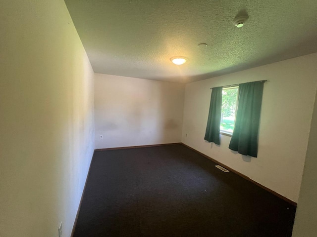 empty room featuring carpet flooring and a textured ceiling