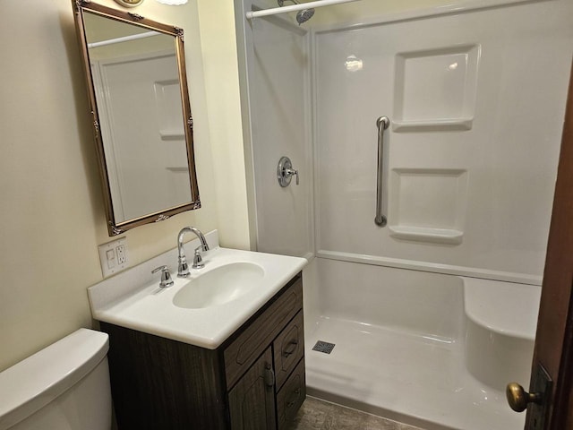 bathroom with vanity, toilet, and a shower