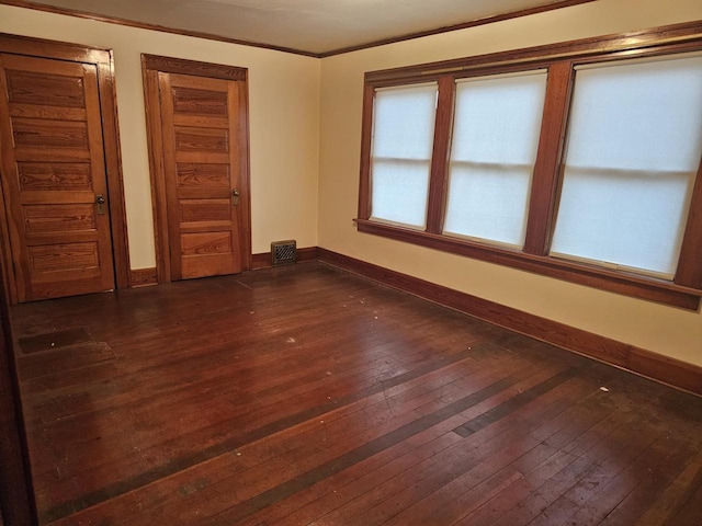 spare room featuring dark hardwood / wood-style floors and ornamental molding