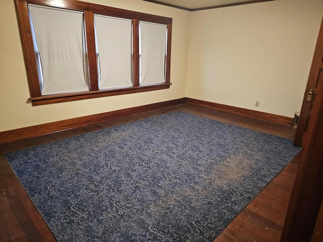 spare room with wood-type flooring and crown molding