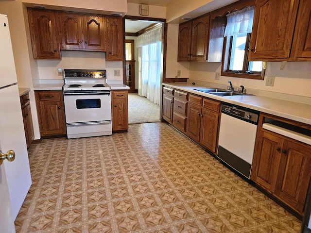 kitchen with white appliances, crown molding, a healthy amount of sunlight, and sink