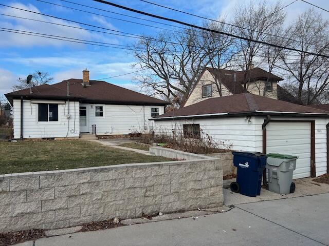 view of side of property with a lawn and a garage