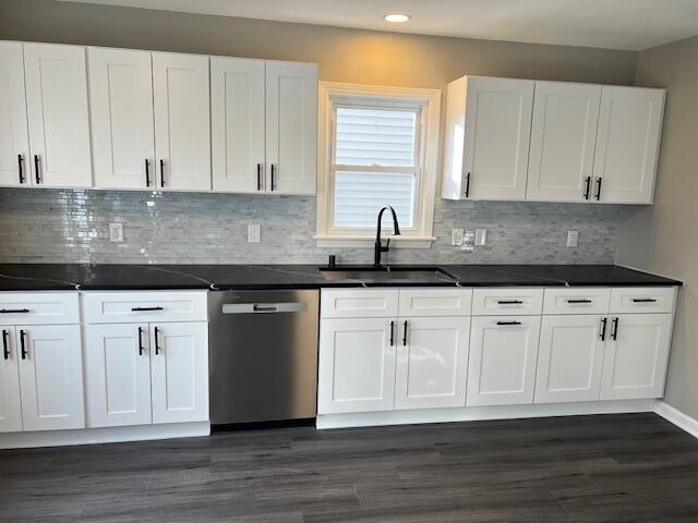 kitchen with white cabinetry, stainless steel dishwasher, dark wood-type flooring, and sink