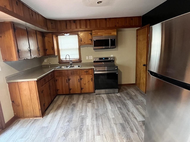 kitchen with sink, light hardwood / wood-style floors, and appliances with stainless steel finishes