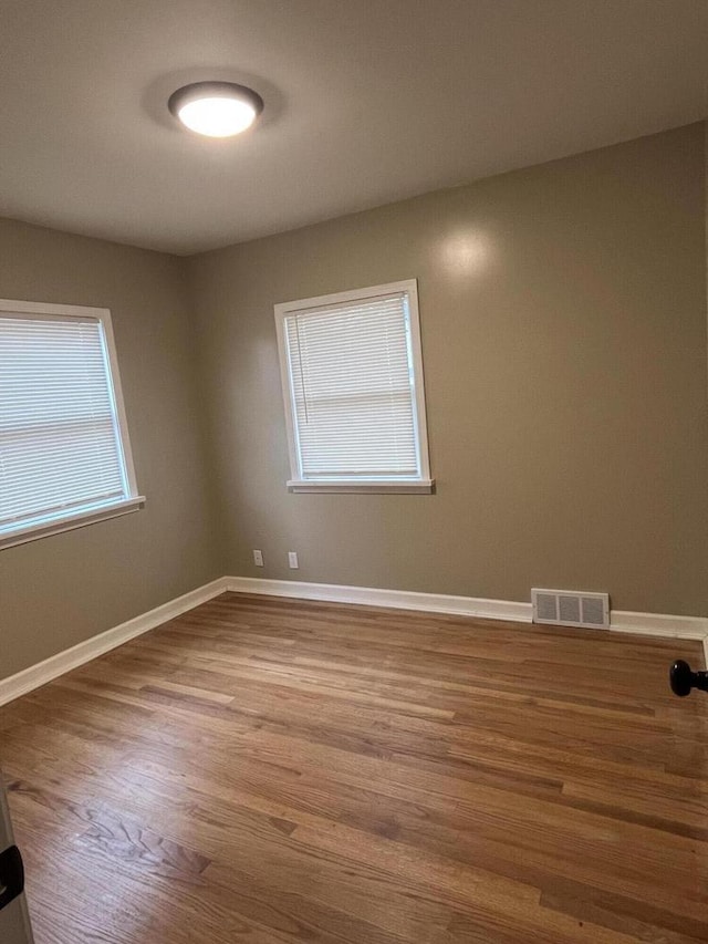 unfurnished room with hardwood / wood-style floors