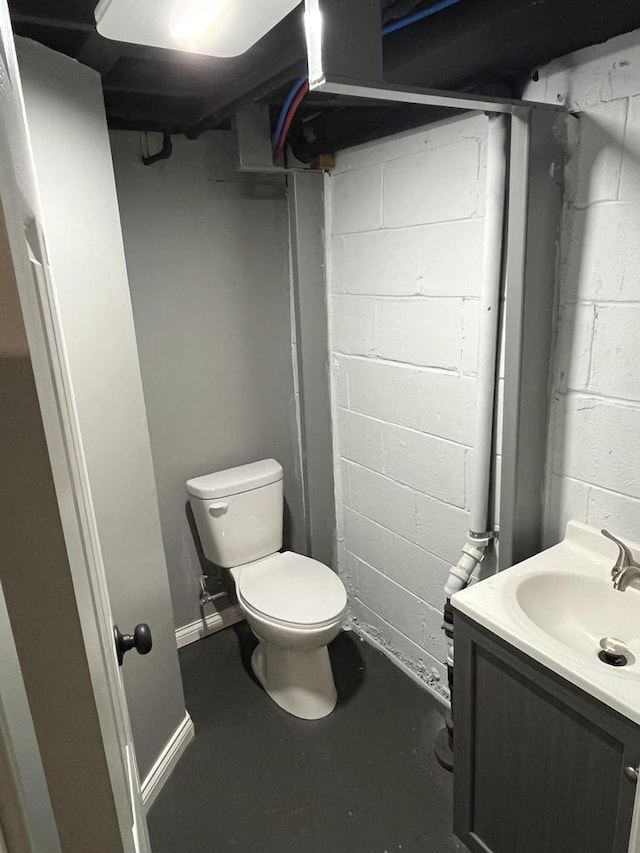 bathroom with vanity, concrete floors, and toilet