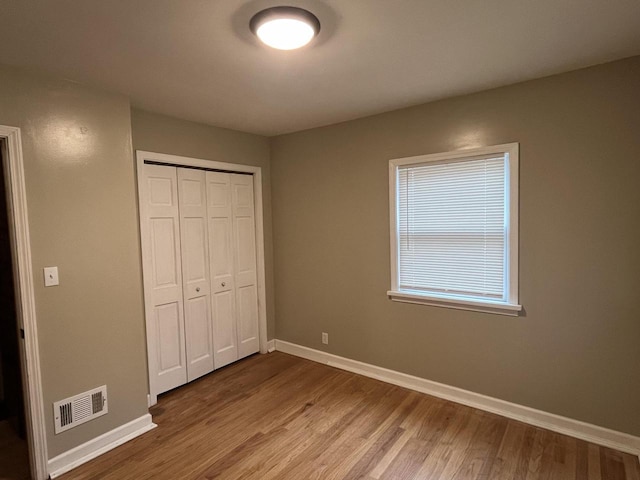 unfurnished bedroom with hardwood / wood-style flooring and a closet