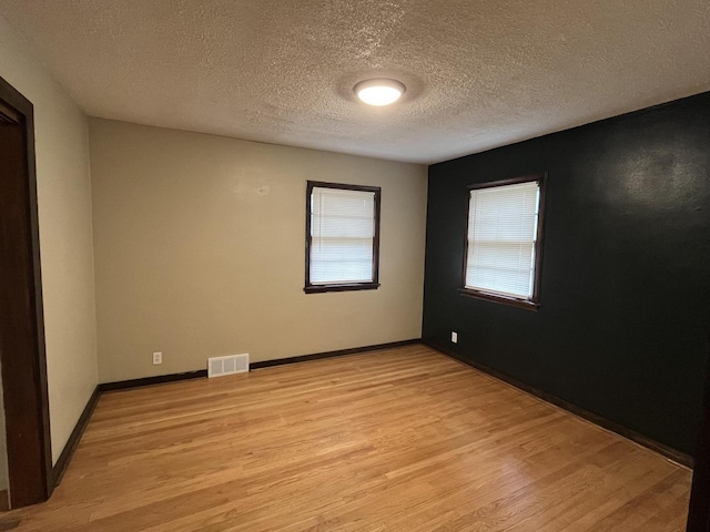 empty room featuring light hardwood / wood-style floors and a textured ceiling