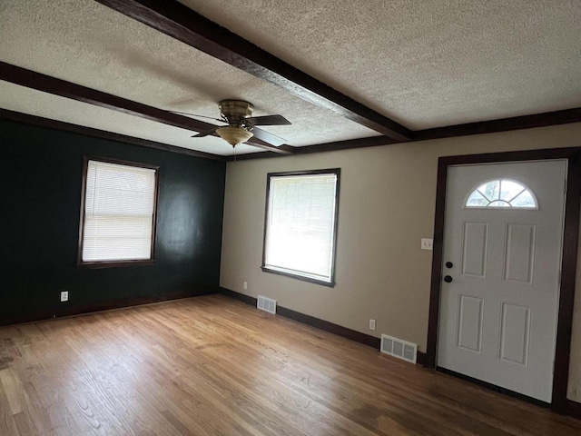 entrance foyer with ceiling fan, a textured ceiling, beam ceiling, and light hardwood / wood-style flooring