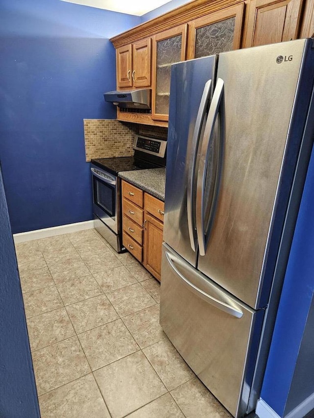 kitchen featuring light tile patterned flooring, backsplash, and appliances with stainless steel finishes