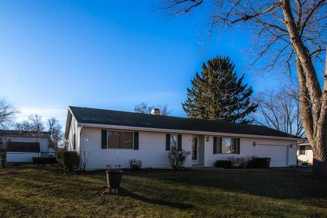 single story home featuring a garage and a front lawn