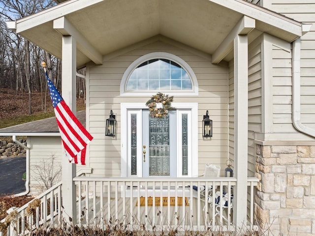 view of exterior entry featuring covered porch