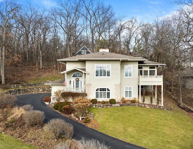 view of front of property with a balcony and a front yard