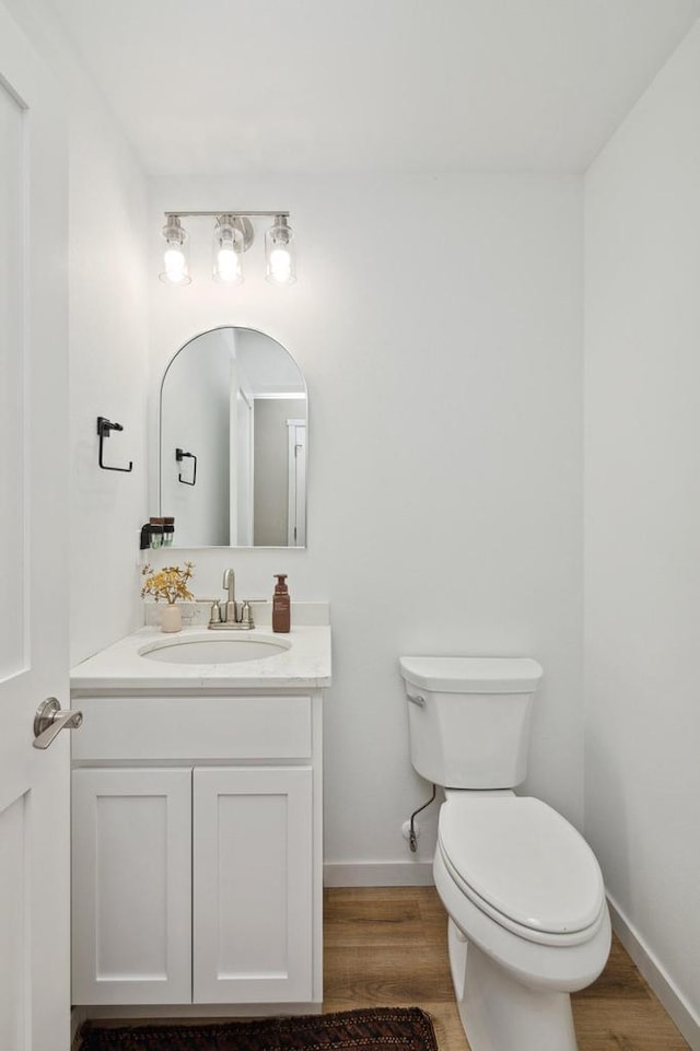 bathroom with vanity, toilet, and wood-type flooring