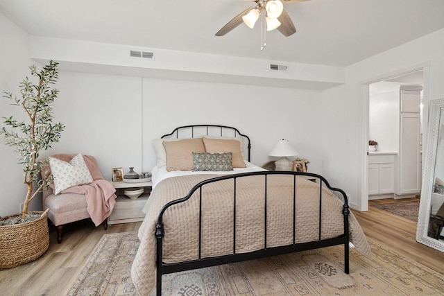 bedroom featuring ceiling fan, light hardwood / wood-style floors, and ensuite bathroom