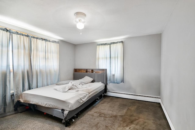 carpeted bedroom with ceiling fan and a baseboard heating unit