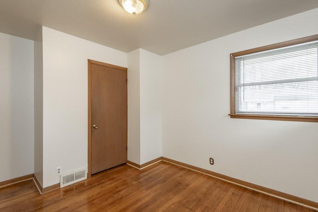 spare room featuring wood-type flooring