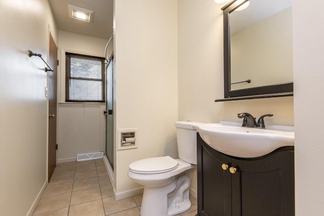 bathroom featuring tile patterned floors, vanity, a shower with shower door, and toilet