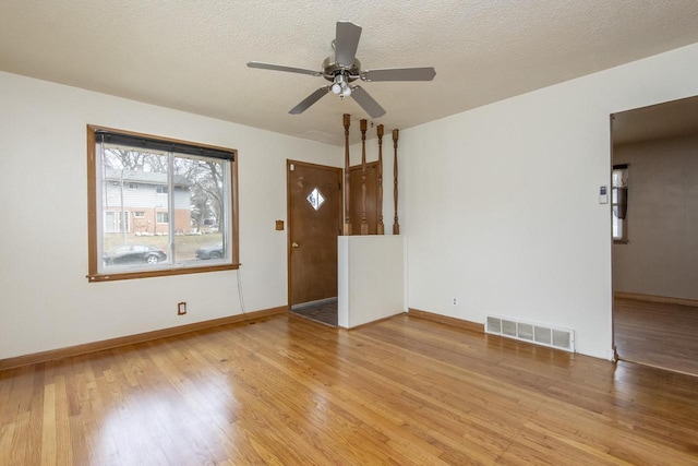 unfurnished living room featuring hardwood / wood-style floors, ceiling fan, and a textured ceiling