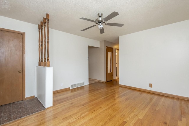 spare room with a textured ceiling, hardwood / wood-style flooring, and ceiling fan