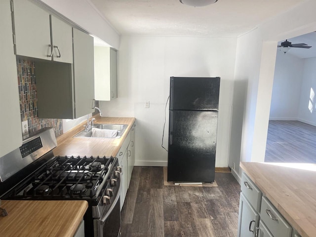 kitchen with ceiling fan, sink, black fridge, stainless steel range with gas cooktop, and dark hardwood / wood-style floors