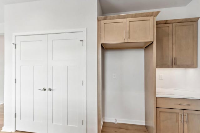 kitchen featuring light hardwood / wood-style floors and light stone countertops