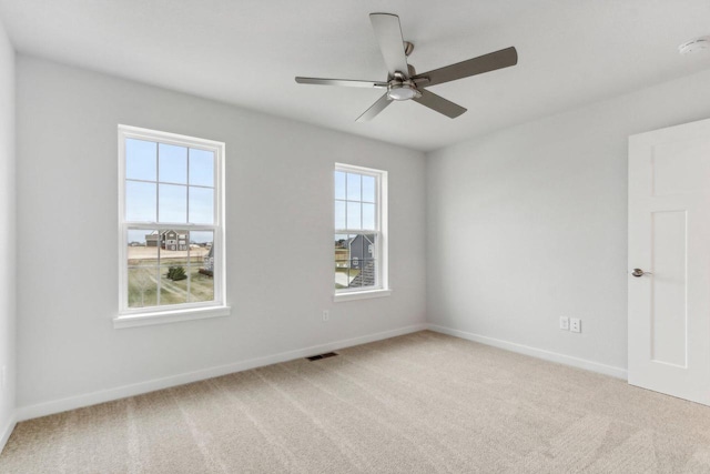 carpeted spare room with ceiling fan