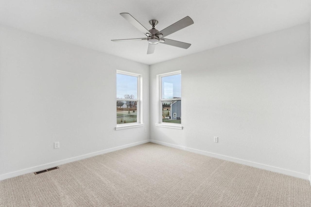 carpeted spare room with ceiling fan