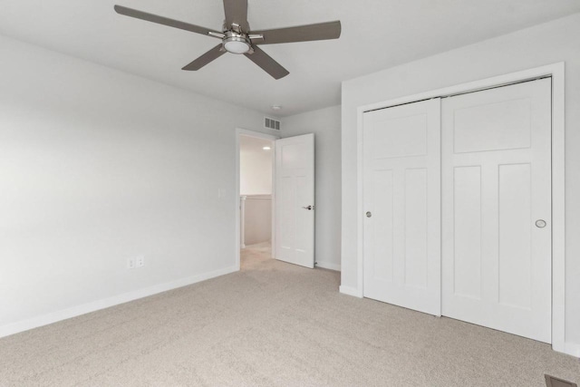 unfurnished bedroom featuring light carpet, a closet, and ceiling fan