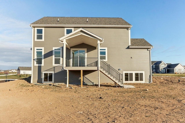 back of house featuring a wooden deck and stairs