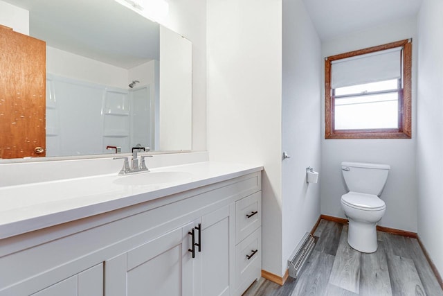 bathroom featuring vanity, toilet, wood-type flooring, and a shower